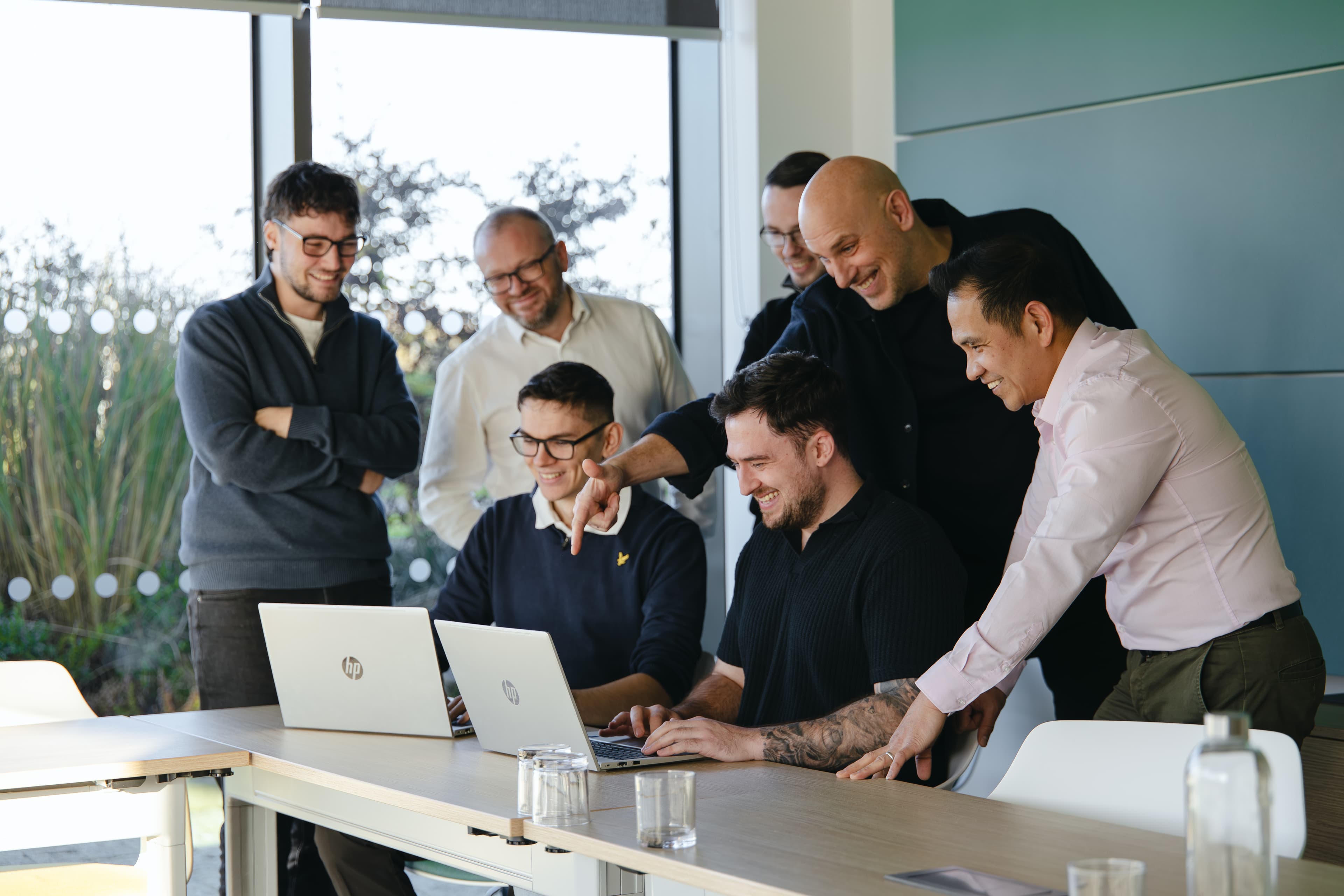 The Cyber Trust team working together around a laptop